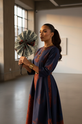Femme en tenue moderne utilisant l'éventail en wax et cuir